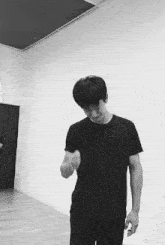a man in a black shirt is standing in a room
