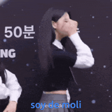 a woman covering her face in front of a sign that says soyedemoli