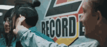 a group of people are standing next to each other in front of a record sign .