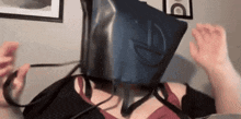 a woman is wearing a rubber mask on her head while sitting on a bed .