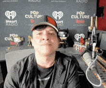 a man in front of a wall that says pop culture on it