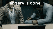two men are sitting at a table with a laptop and the words `` anger is gone '' written above them .