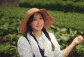 a woman wearing a straw hat and a white towel around her neck
