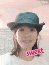 a woman wearing a cowboy hat and ear buds has the word sweet written on her face