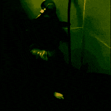 a silhouette of a person standing in a dark room with a green background