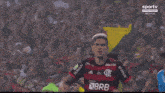 a soccer player is kneeling down on the field in front of a crowd of people .