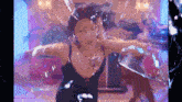 a woman is dancing in a room with a broken glass wall .