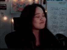 a woman is giving the middle finger in front of a white board that says ' i love you ' on it