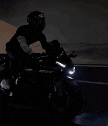 a man wearing a helmet is riding a yamaha r1 motorcycle