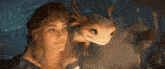 a woman is holding a small creature with horns on its head