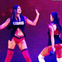 a couple of women are dancing on a stage .