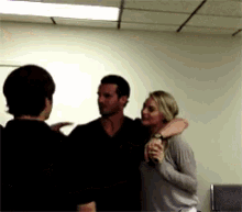 a man and a woman are hugging in a room