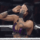 a woman with a tattoo on her arm covering her face