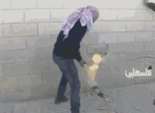 a man wearing a scarf is holding a torch in front of a brick wall .