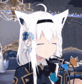 a girl with white hair and cat ears is sitting in front of a microphone