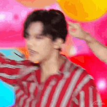 a blurry picture of a man in a red and white striped shirt dancing .