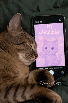a cat laying next to a phone that says hi jezzie on the screen