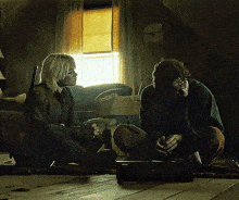 a man and a woman are sitting on the floor talking