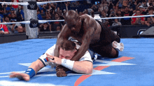 two men are wrestling in a wrestling ring with the letters w on the ring ropes