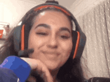 a woman wearing headphones and a microphone is smiling for the camera