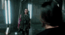 a woman in a dress is standing next to a man in a dark room .