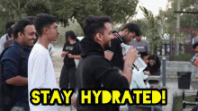 a group of people drinking water with the words " stay hydrated " on the bottom