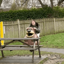 a man putting his hands on a bear trash can