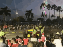 a crowd of people are watching a christmas parade with a jeep driving down the street .