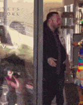 a woman in a colorful costume is standing in front of a glass door that says neys work