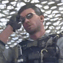 a man wearing sunglasses and gloves is standing in front of a fence