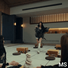 a woman is standing in a room with ms written on the bottom of the screen