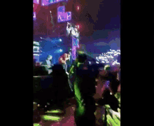 a group of people are standing on a stage in front of a crowd at a concert .