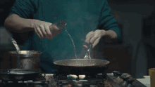 a person cooking on a stove with flames coming out of it