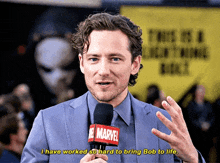 a man in a suit is talking into a microphone with the words " i have worked so hard to bring bob to life "