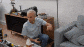 a man is sitting on the floor in a living room playing with a lego house .
