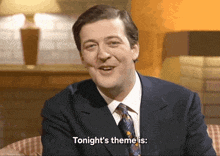 a man in a suit and tie is saying " tonight 's theme is "