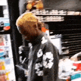 a man is standing in front of a refrigerator in a store .