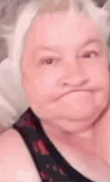 an elderly woman is making a funny face with her mouth open .
