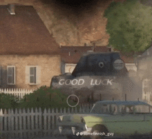 a tank with the words `` good luck '' painted on the side is driving down a street .