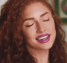 a close up of a woman 's face with her eyes closed and pink lipstick on her lips .