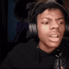 a man wearing headphones is making a funny face while sitting in a chair .