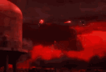a person is standing in a dark room with red lights coming out of the ceiling .
