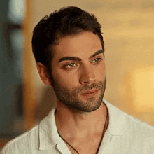 a man with a beard wearing a white shirt