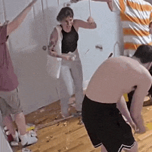 a group of people are standing in a room with a woman holding a hammer