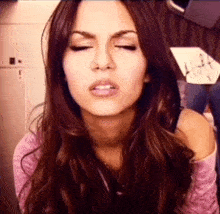 a close up of a woman 's face with her eyes closed .