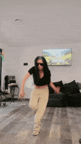 a woman is dancing in a living room in front of a television