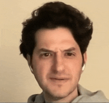 a man wearing headphones is making a funny face while looking at the camera .