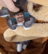 a person is holding a picture of a man with a mustache in their paws