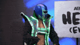 a wrestler stands in front of a sign that says he on it