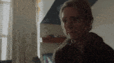 a woman in a green coat is sitting in a living room .